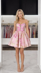 Front view of model wearing pink strapless floral brocade mini dress