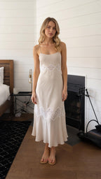 Front view of woman wearing beige lace trim pleated slip midi dress
