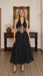Front full view of black polka dot halter midi dress on model