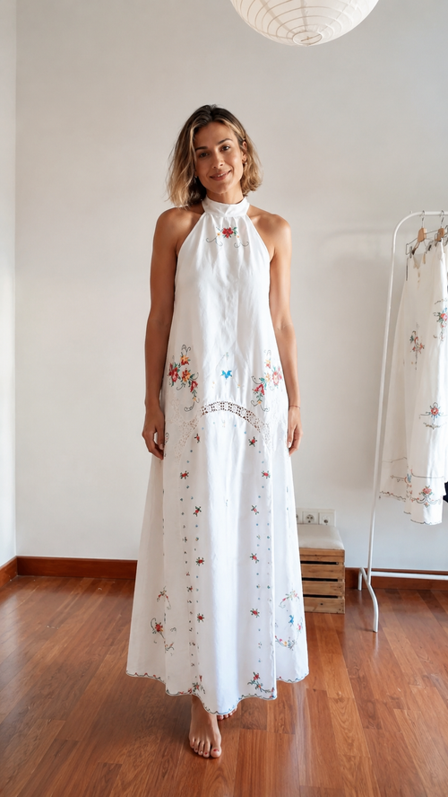 Front view of white embroidered halter maxi dress with floral details