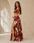 Woman wearing a red floral off shoulder crop top and high slit maxi skirt set front side view