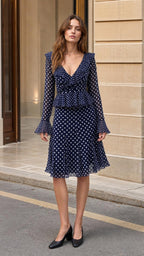 Front view of model wearing Navy polka dot midi dress
