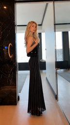 Side view of black striped fitted maxi dress with flared hem