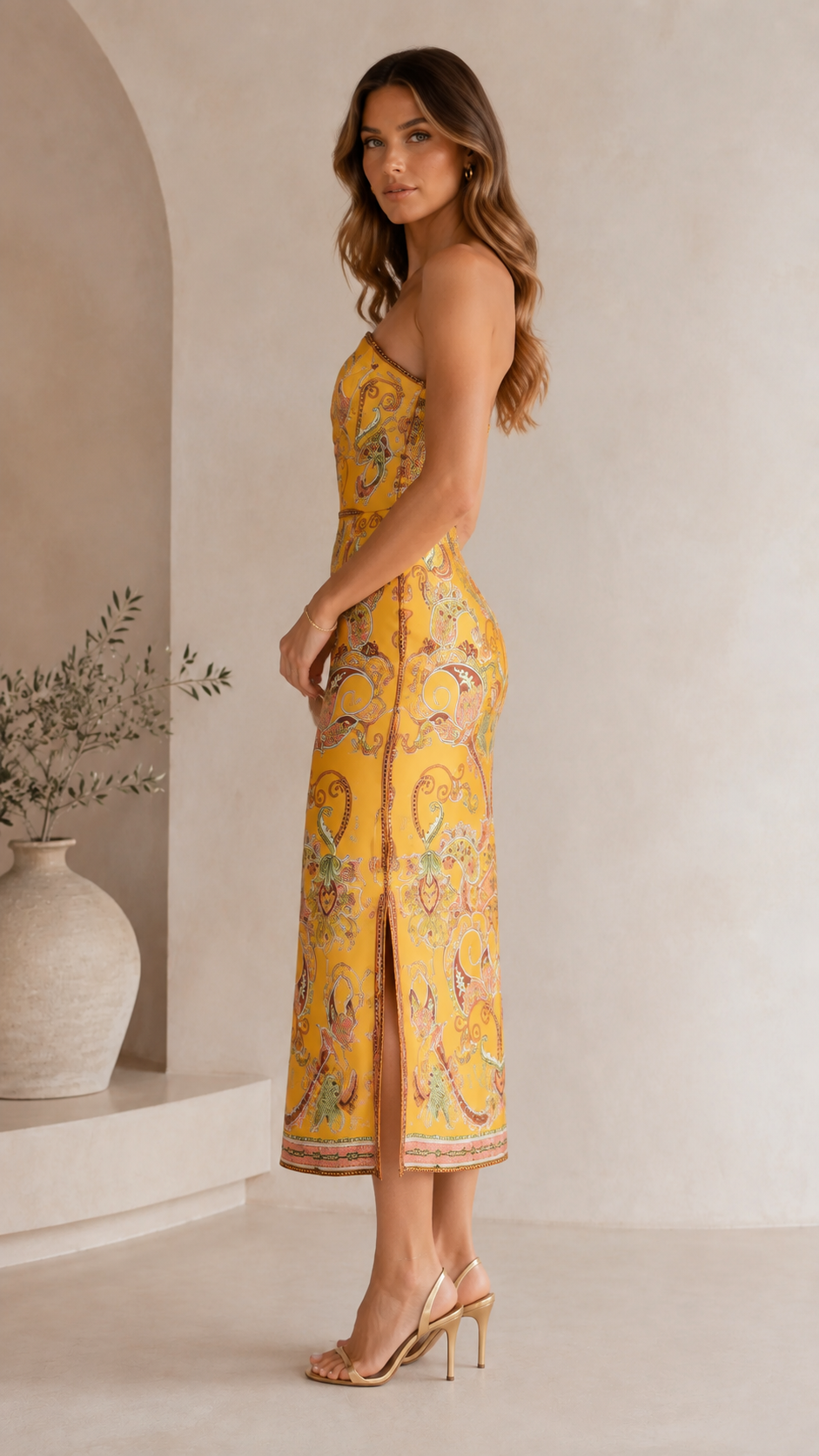 Side view of marigold strapless fitted midi dress with side slit