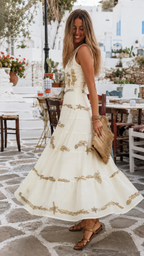 Side view of ivory sleeveless embroidered tiered maxi dress with flowing full skirt