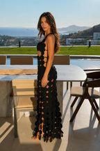 Side profile view of model in black geometric cutout gown