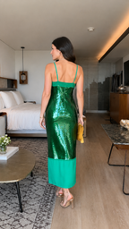 Back view of emerald green sequin slip midi dress with straight back and sheer hem panel