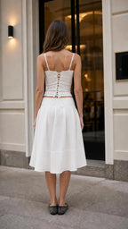 Back view of woman showing lace-up detail on white camisole top