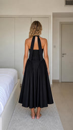 Back view of woman wearing black halter neck midi dress