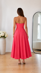 Back view of coral pink strapless midi dress with flared skirt
