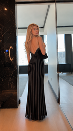 Back view of black striped low-back mermaid maxi dress