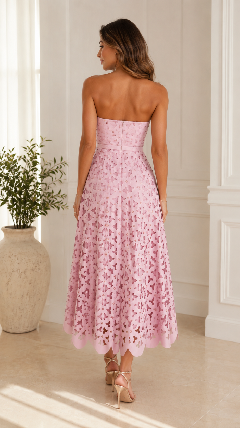 Back view of blush pink strapless midi dress with flared skirt