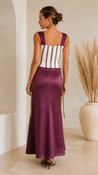 Back view of plum striped corset maxi dress with wide straps