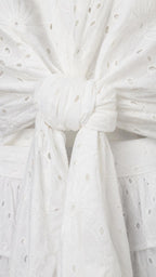 Close-up detail of the front tie closure on white eyelet crop top