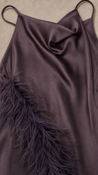 Close-up detail of dark purple satin fabric and feather trim