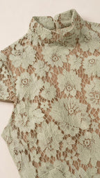 Close-up detail of sage floral lace fabric and mock collar