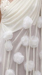 Close-up detail of sheer draped fabric and dimensional floral appliques