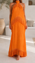 Close front view of orange fringe halter maxi dress showing layered texture and hem
