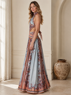 Side view of sky blue printed halter maxi dress showing cutout waist and full skirt