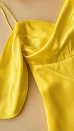 Close-up detail of the cowl neckline and satin fabric in yellow