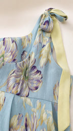 Close-up detail of shoulder bow tie and blue floral print fabric