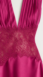 Close-up detail of pleated bodice and floral lace waist on magenta dress
