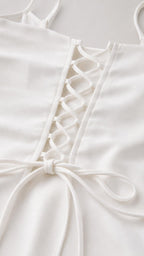 Close-up detail of lace-up back tie on the white cami top