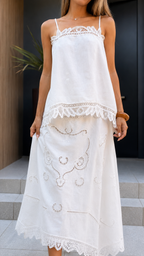 Close-up front detail of white cami top and midi skirt showing lace trim and hem accents