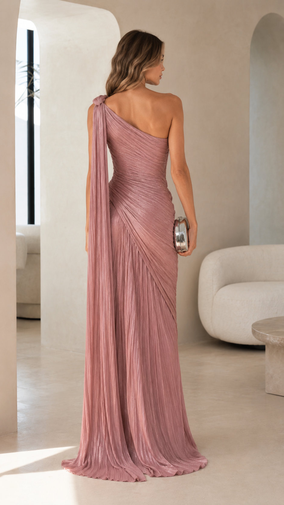 Back view of dusty rose pleated one-shoulder floor-length dress with trailing shoulder drape
