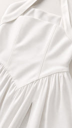 Close-up detail of the structured bodice and fabric on white dress