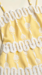 Close-up detail of yellow dress fabric and crochet trim