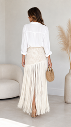 Back view of ivory fringe maxi skirt showing flowing full-length fringe