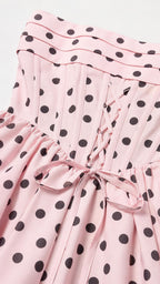 Close-up of the lace-up back and pleated bodice on pink polka dot dress