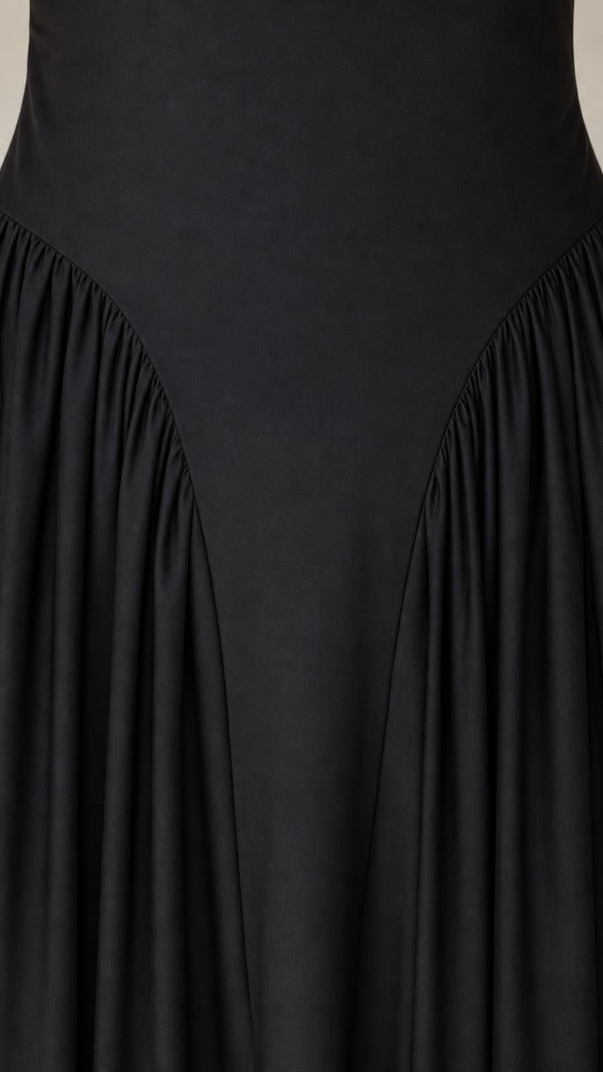 Close-up detail of dropped waist and pleats on black dress