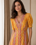 Close-up of marigold printed V-neck bodice with puff sleeves and button detail