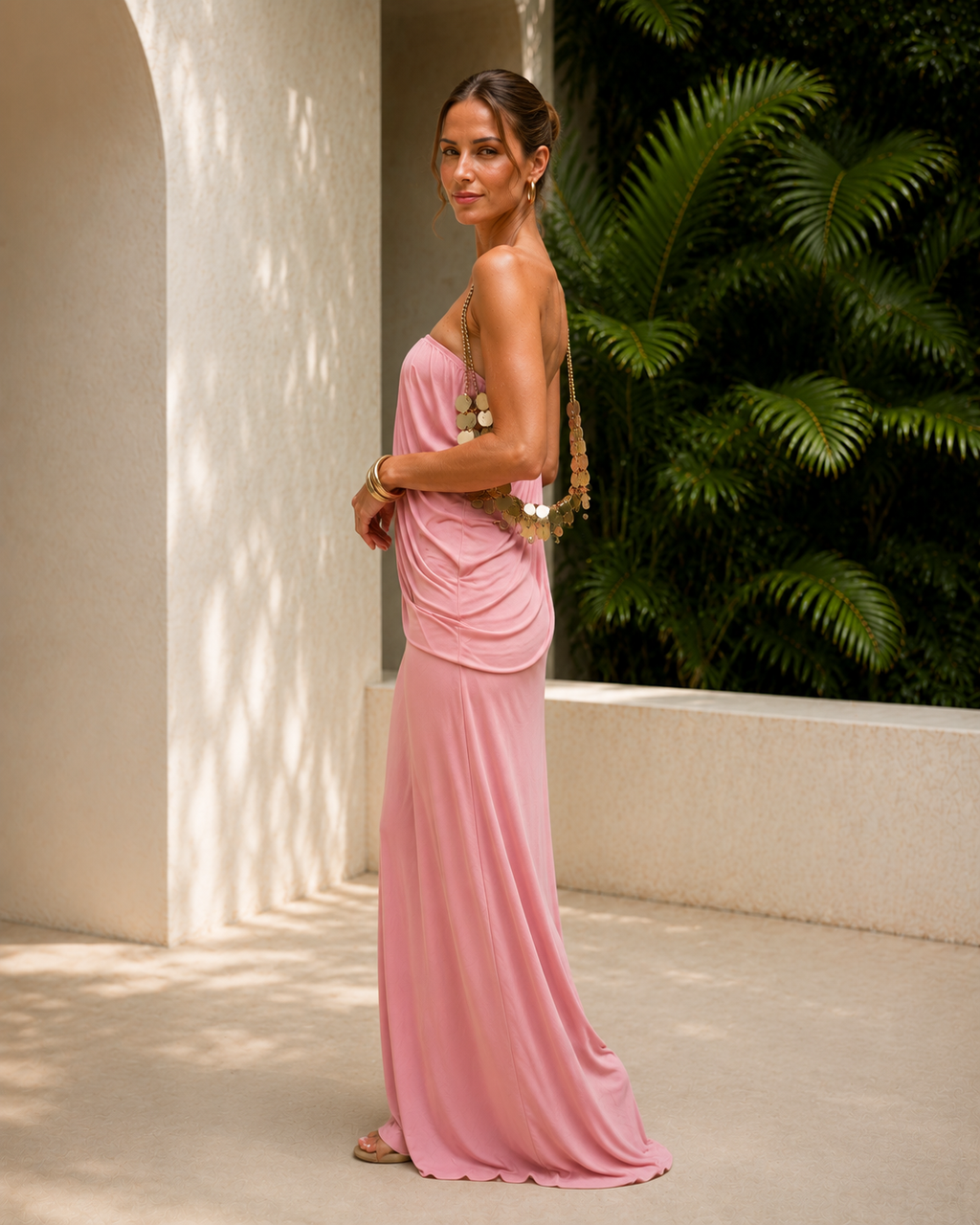 Side view of pink strapless draped maxi dress showing fluid fit