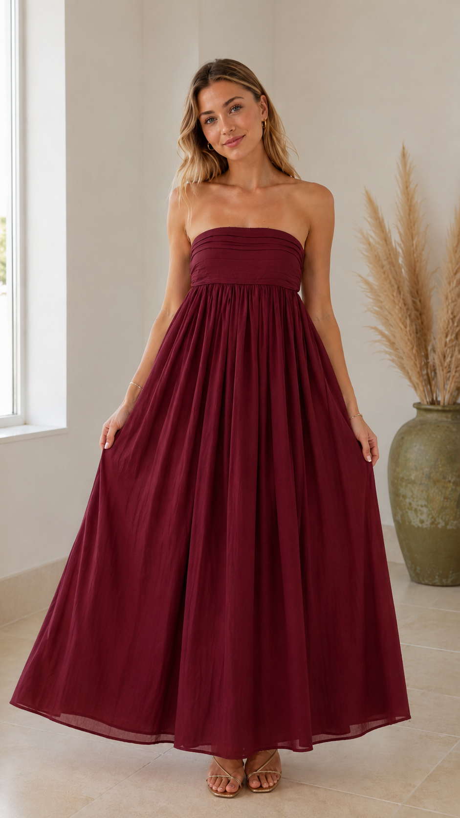 Front view of wine red strapless maxi dress with flowing A-line silhouette