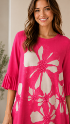 Close-up of hot pink floral dress showing round neckline, floral print, and pleated sleeve cuff