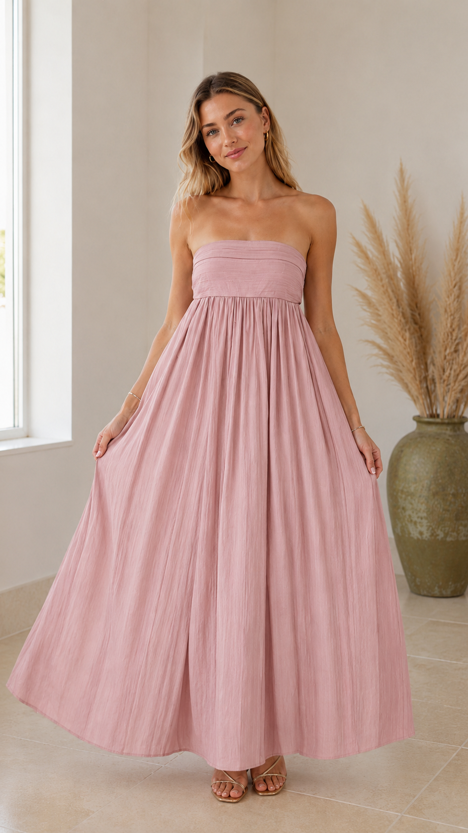 Front view of blush pink strapless maxi dress with smocked-looking bodice